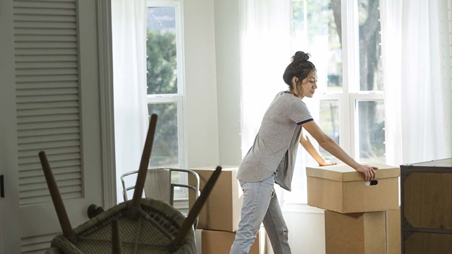 woman moving into rental home and stacking boxes